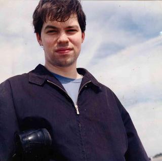 David Rhoden on Coney Island holding a penny loafer, 1990s